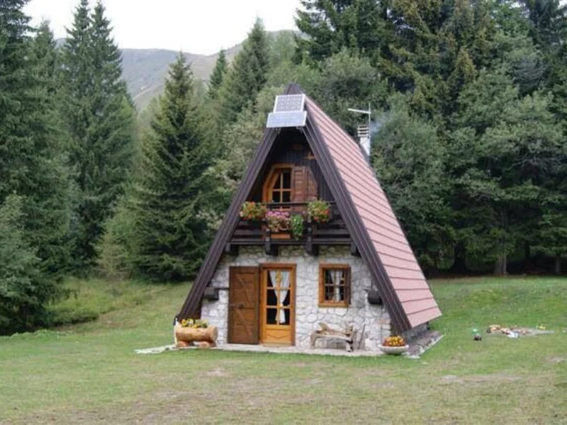Chalé A-frame em construção com janelas sendo instaladas